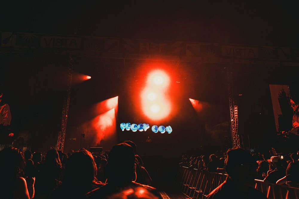 A series of dark concert photos showing red stage lighting and silhouettes of performers and crowd at a music venue.