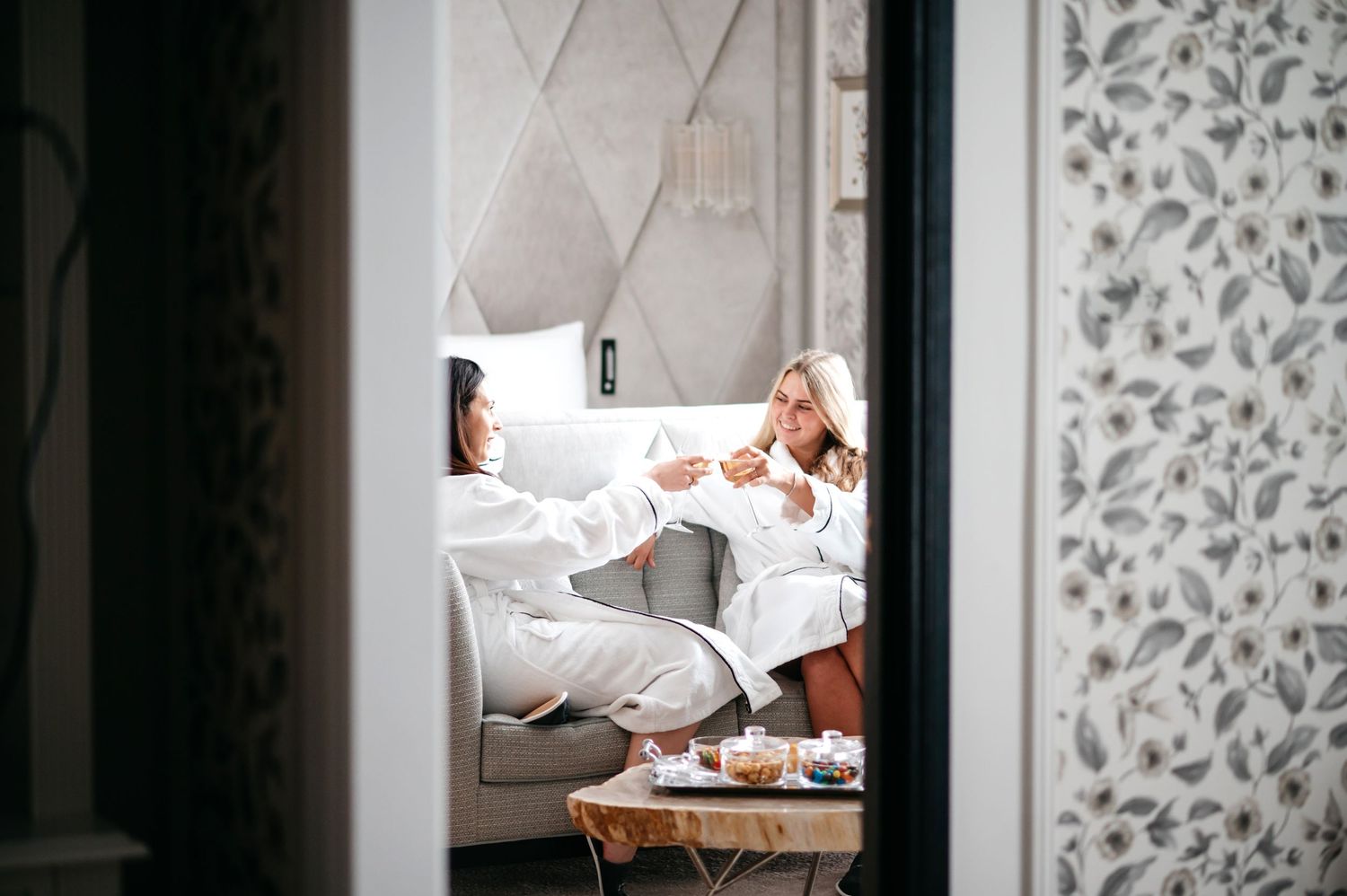 brand and lifestyle photography for fairmont windsor park. two women having breakfast in luxury hotel room.