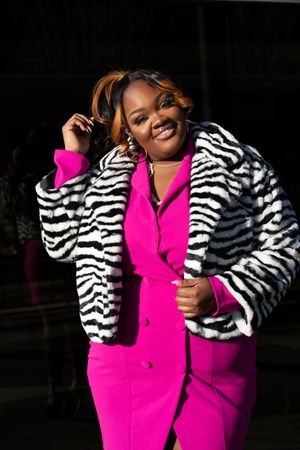 A vibrant pink outfit paired with a zebra print cropped jacket creates a bold fashion statement.