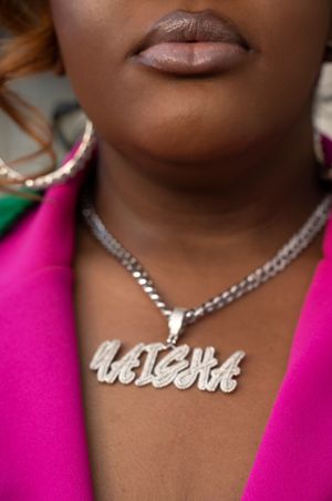 A silver chain necklace with a custom nameplate pendant shown in close-up detail.