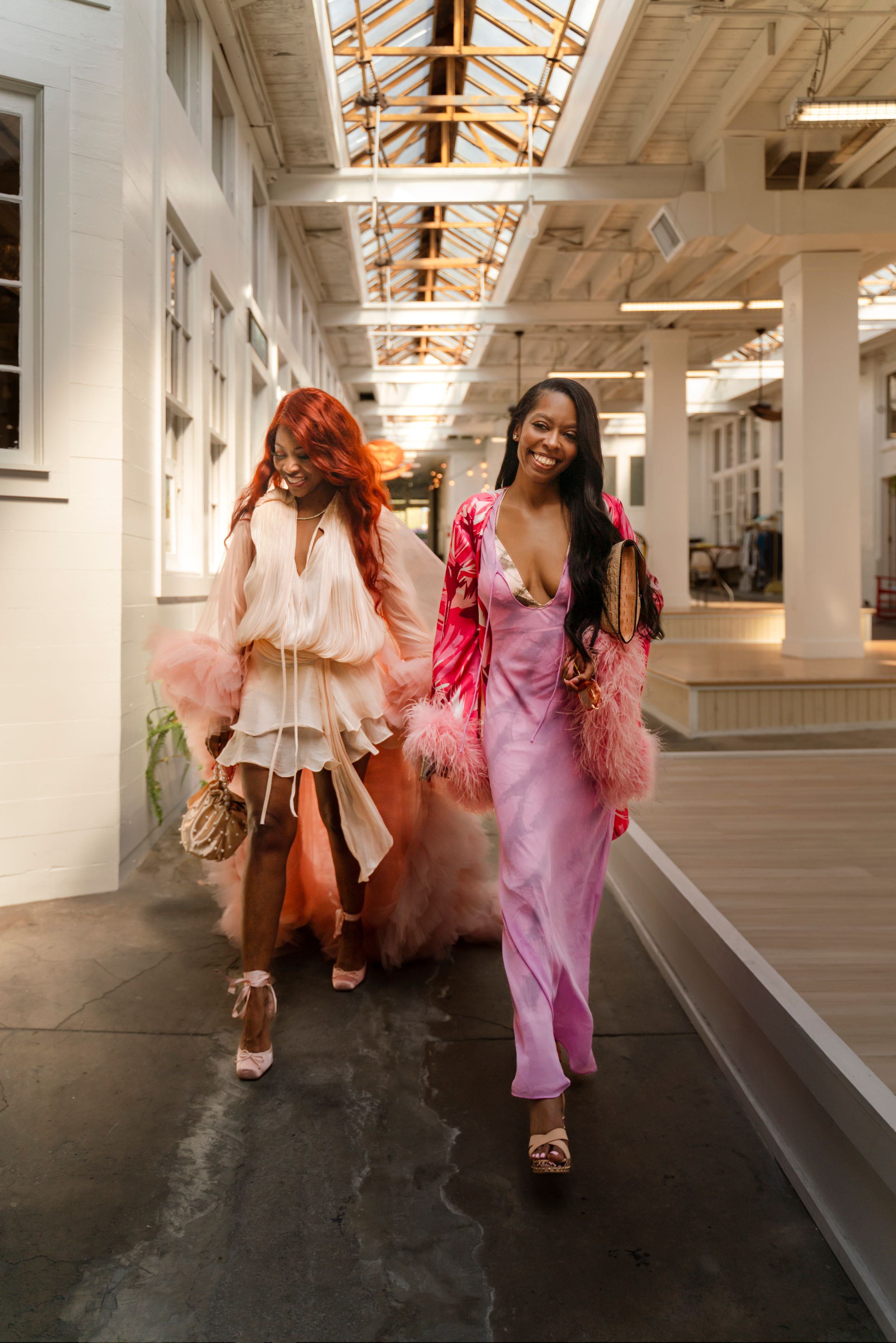 A sequence of five photos showing dancers in flowing dresses moving through a bright industrial space with skylights.
