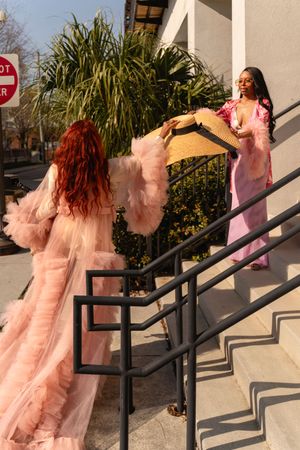 Series of photos showing someone in a pink tulle dress posing on white building steps with handrails.