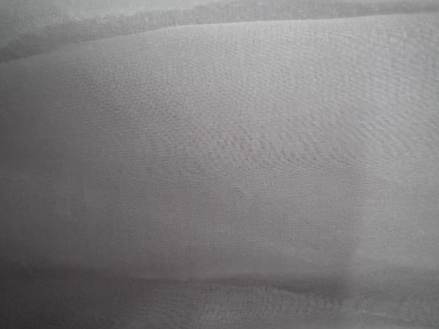 A sample of a gray chiffon silk fabric that can be worn by maternity photography clients.