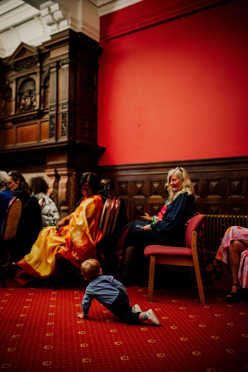 A sequence of photos showing two people in a dramatic performance on a red carpeted floor with wooden paneled walls.
