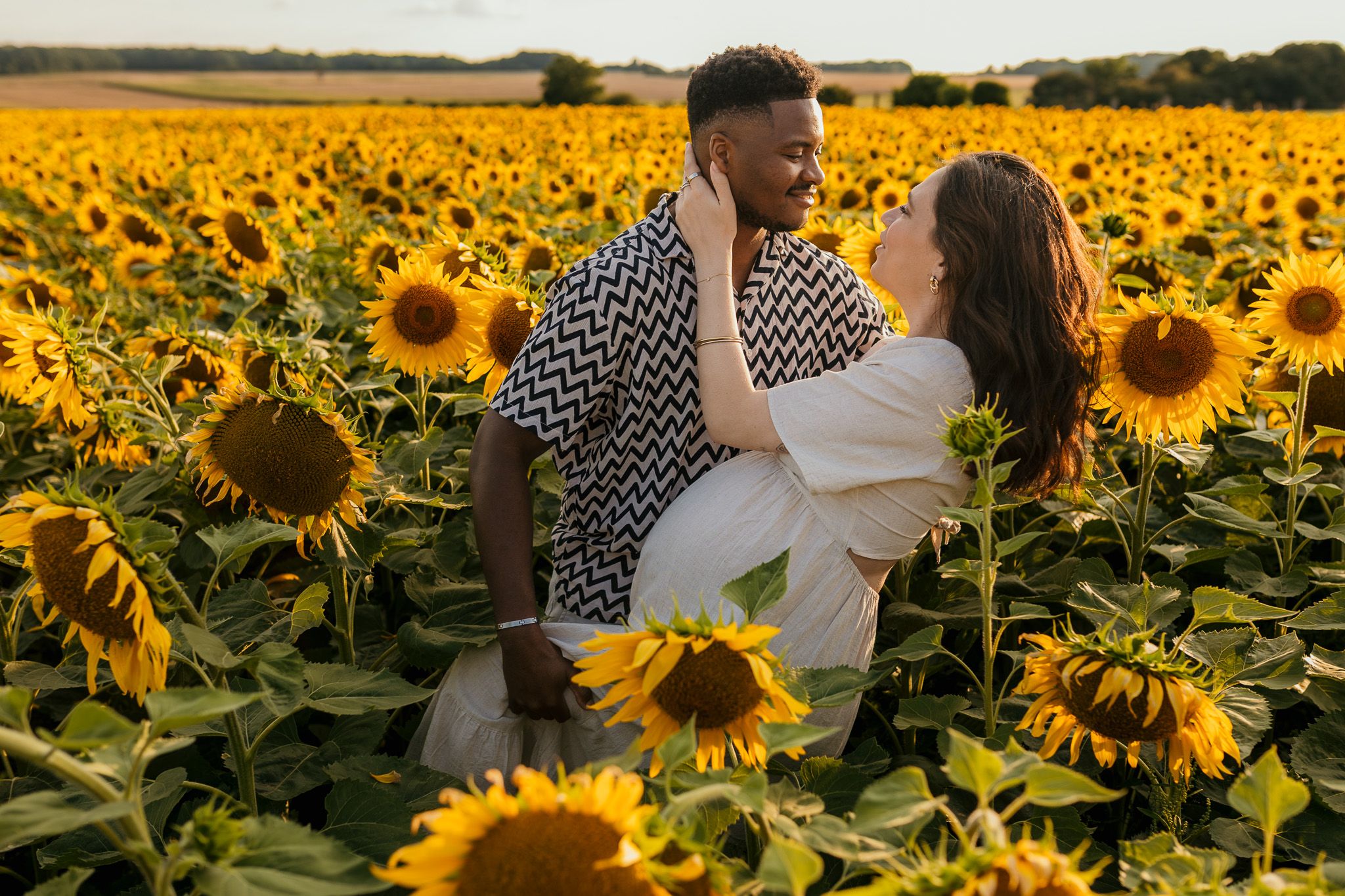 Couple enlacé dans un champ de tournesols