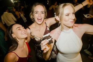 People dancing and celebrating at a lively wedding reception party on a dance floor.