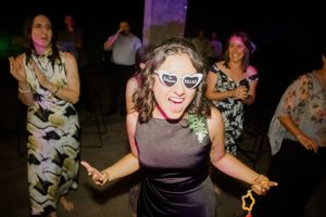 People dancing and having fun at a lively party with colorful lighting and festive atmosphere.