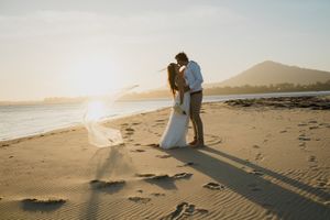 Panoramic sequence of a romantic beach photoshoot at sunset with silhouettes walking along the sandy shoreline.