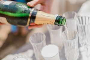 Pouring champagne into elegant flute glasses at a celebration event.