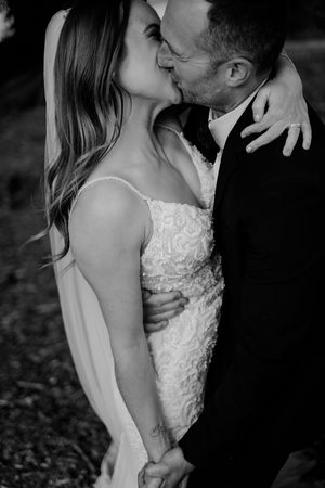 Black and white romantic wedding photos showing intimate close-up moments between newlyweds sharing tender kisses.