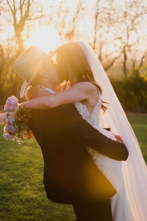 A romantic sunset wedding photo series shows a couple embracing outdoors with a flowing white veil and bouquet.
