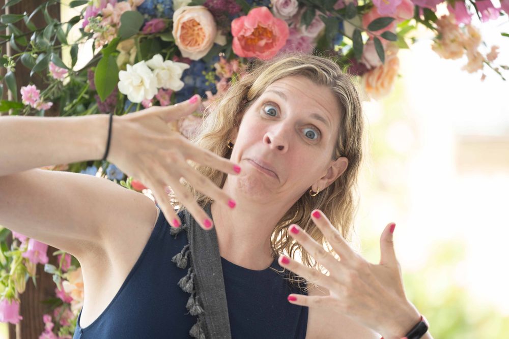 A collage of someone making silly faces while posing with pink and white flowers in a garden setting.