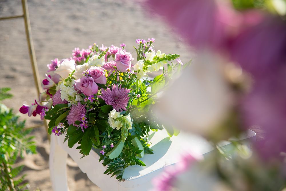 Pink and white floral arrangement in a white vase with soft focus background.