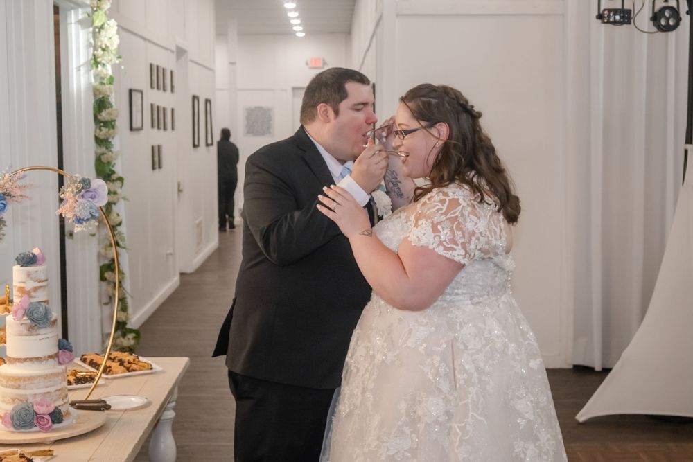 Bride and groom sharing a sweet cake-cutting moment at their elegant wedding reception.