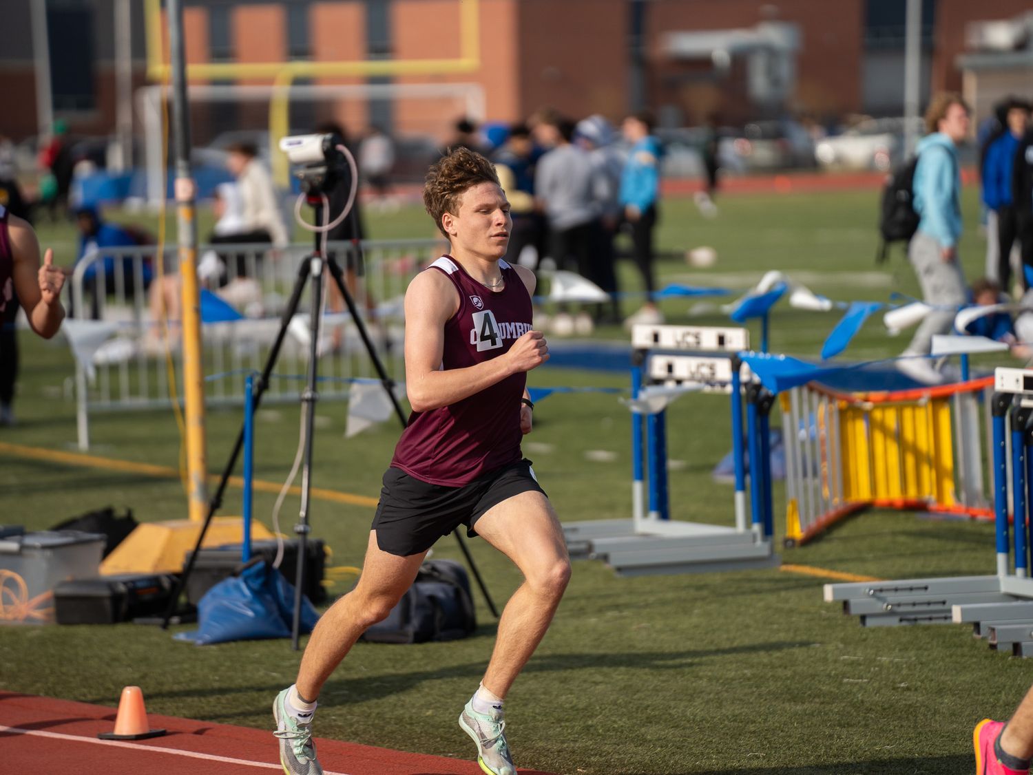 Runner competes on outdoor track during sunny day competition.