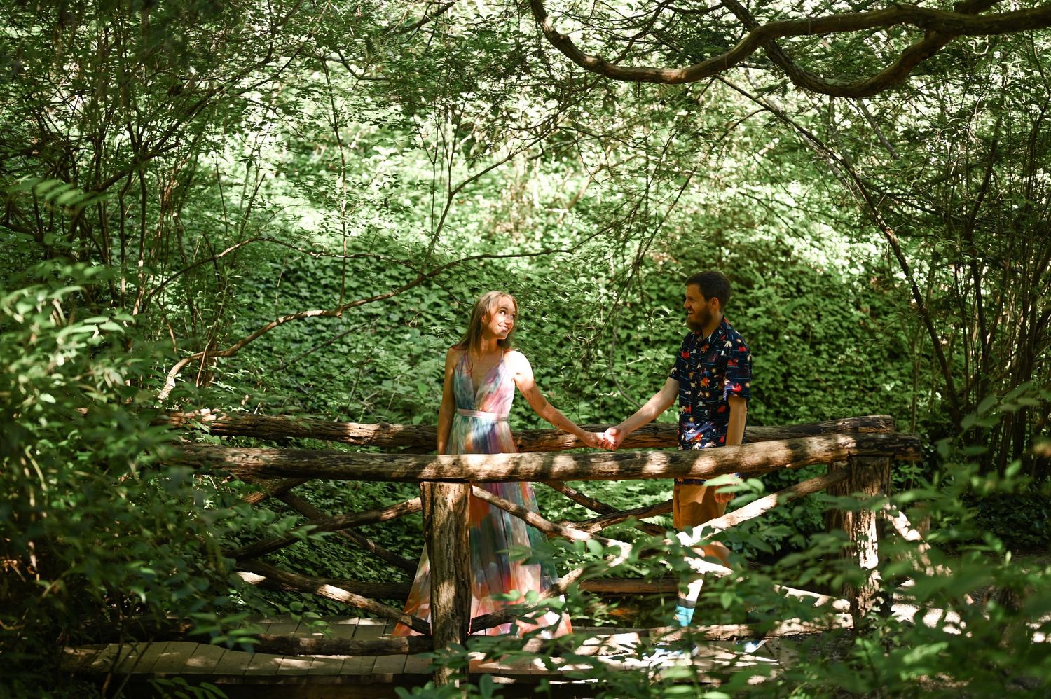 A lush garden path surrounded by green foliage and trees creates a natural walkway.