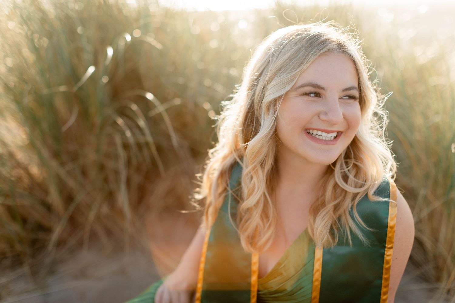 Golden hour college graduation portrait session in natural setting with warm backlighting.