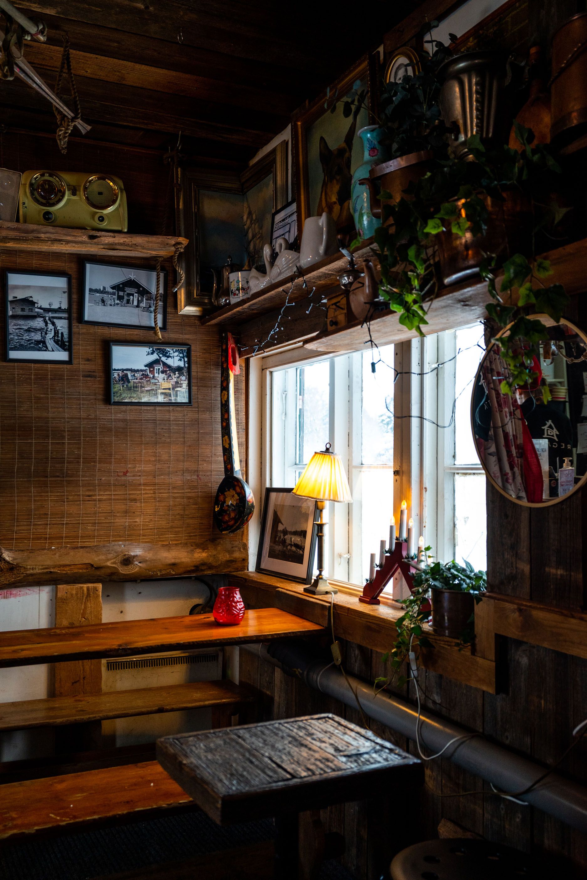 Cozy rustic cabin interior with wooden benches, vintage decor, and windows letting in natural light.