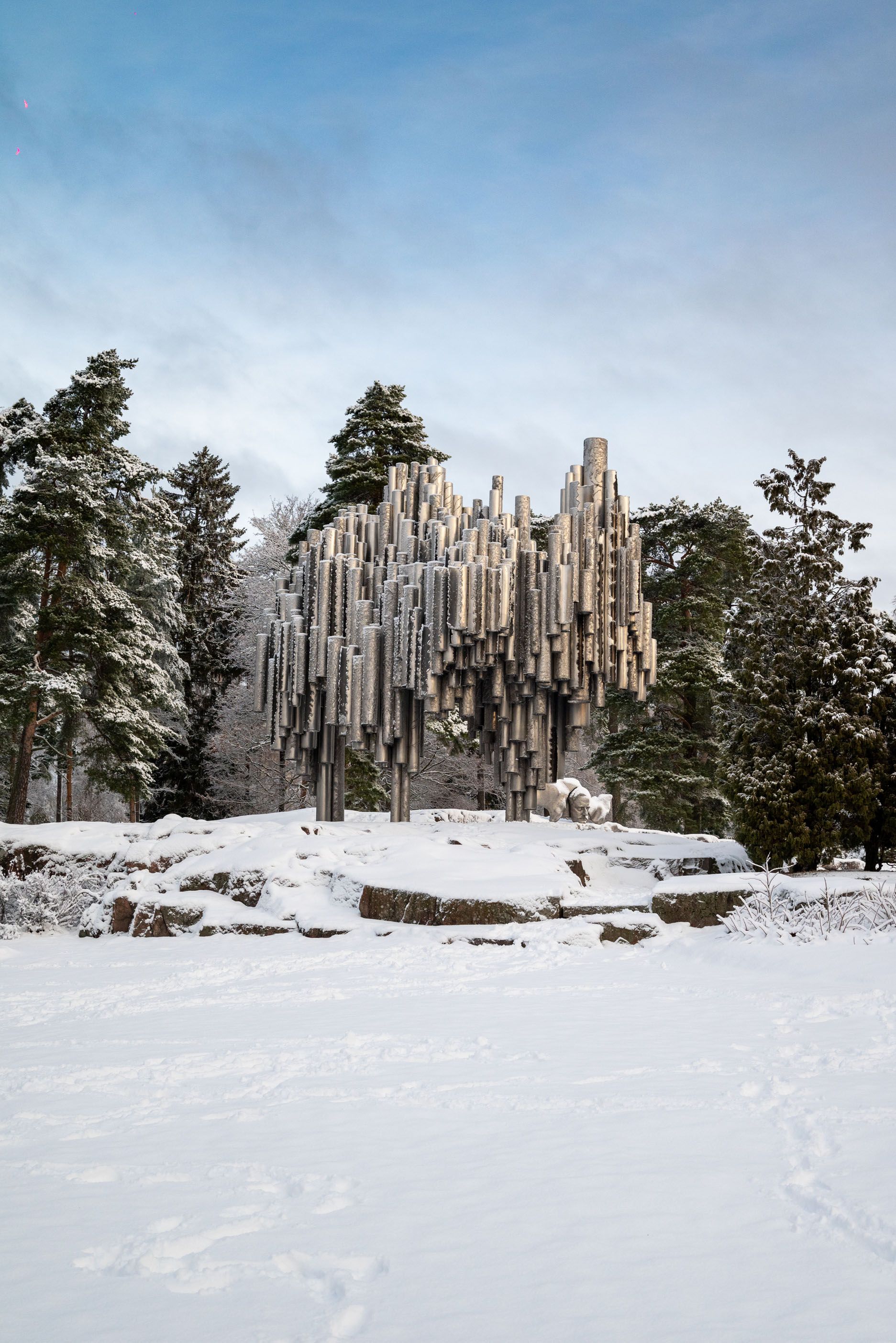 A magical winter landscape in Lapland, Finland, featuring snow-covered trees and the Northern Lights dancing in the sky. Discover how to vis