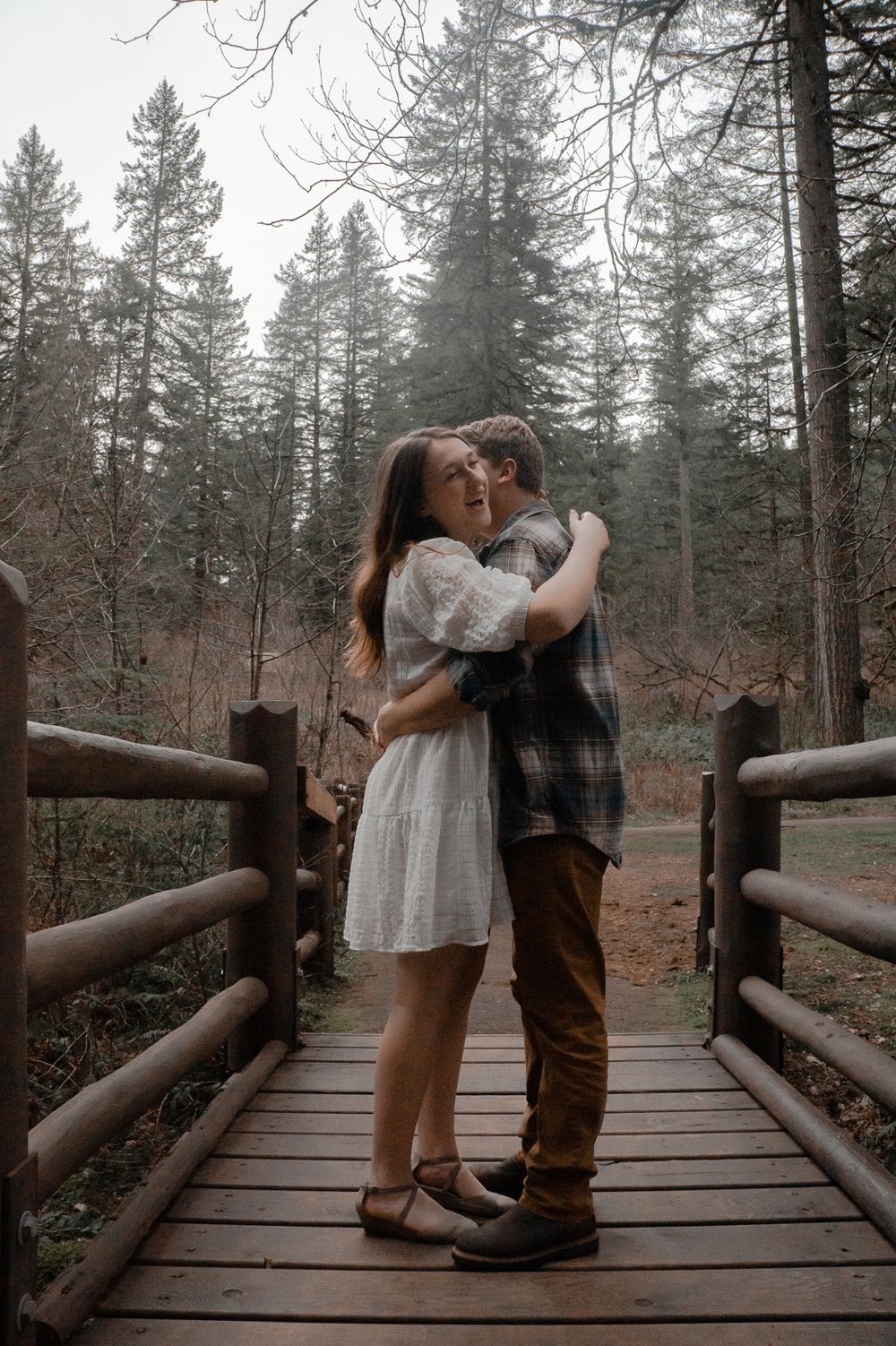 Couple wrapped in an embrace on a rustic wooden bridge during romantic photo session in Salem OR