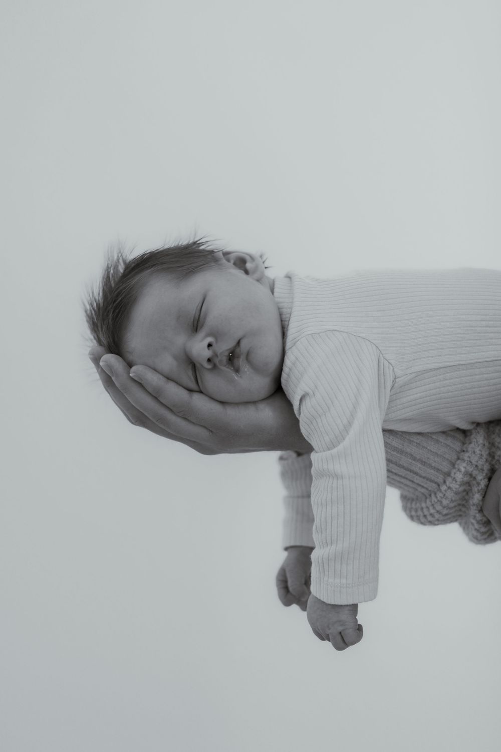 Minimalist black and white newborn portrait of baby sleeping during lifestyle session