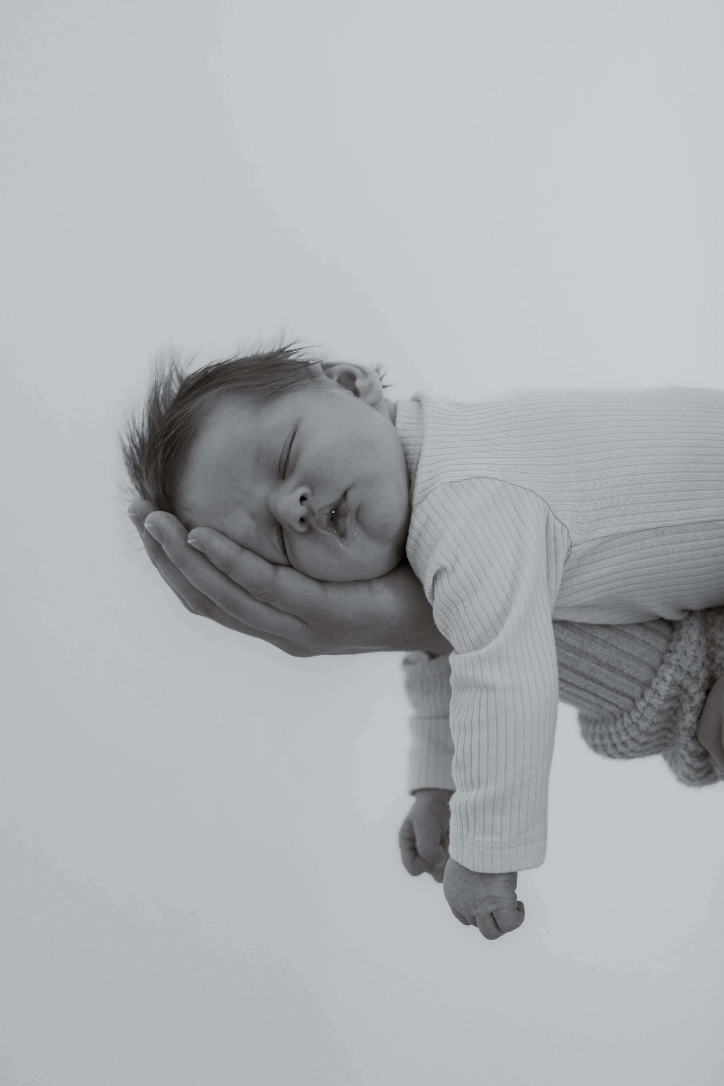 Minimalist black and white newborn portrait of baby sleeping during lifestyle session