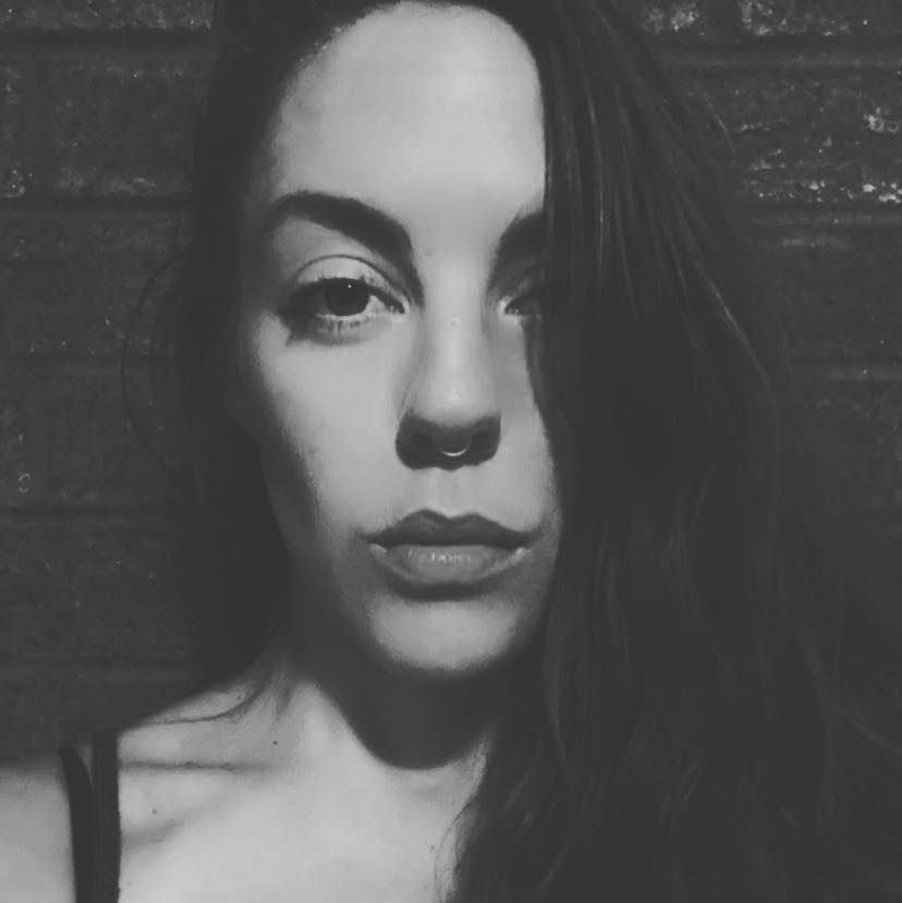 A black and white artistic portrait featuring dramatic lighting, shadows, and a moody aesthetic style.