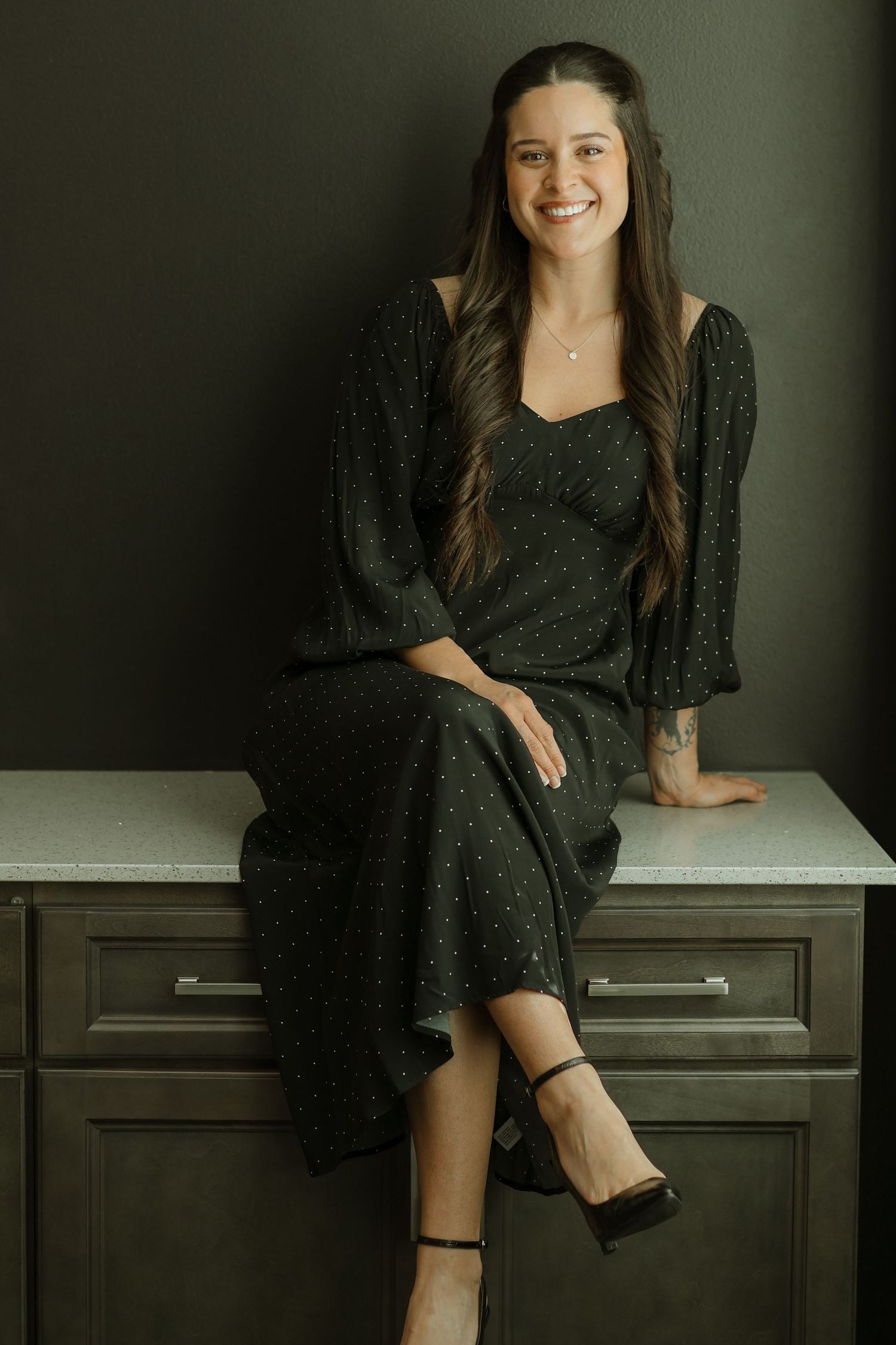 Series of casual portraits showing woman in dark dress sitting on wooden furniture.