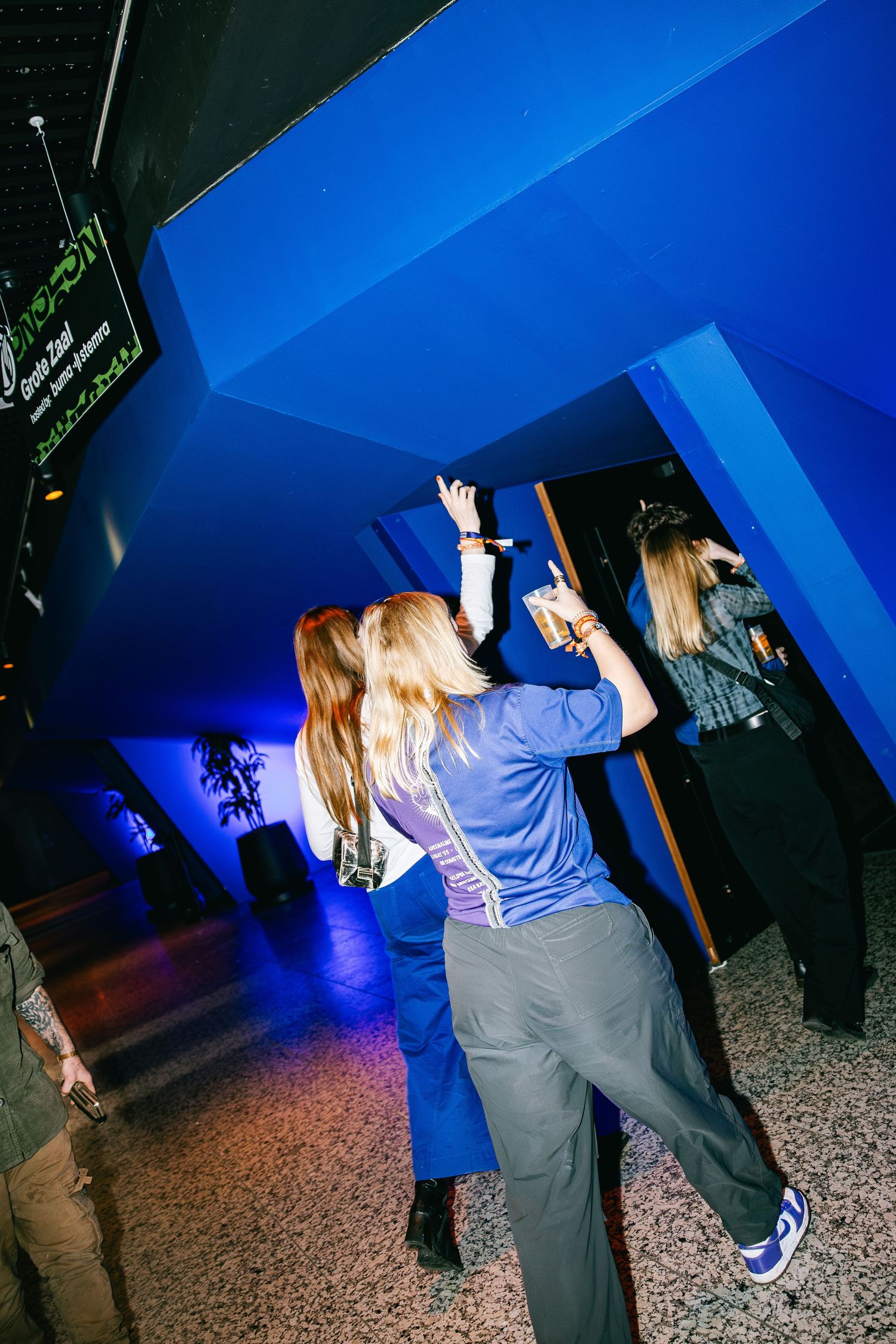 A sequence of photos showing people dancing in a dimly lit room with blue lighting and a speckled floor.