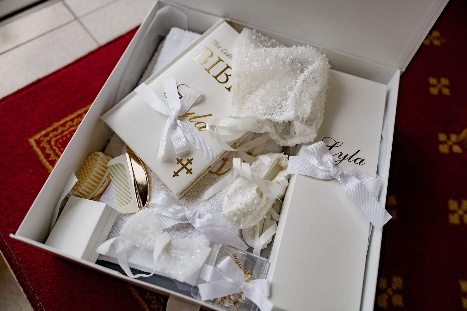 White baptismal accessories and clothing arranged neatly in a gift box.