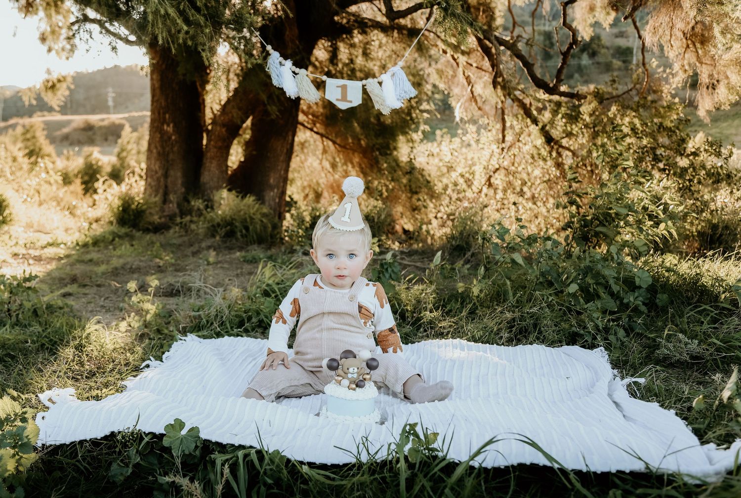 A little man ready to hook into his cake smash.