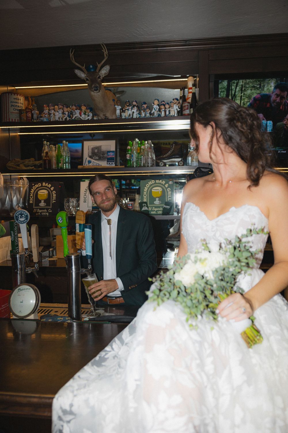 Wedding celebration at a bar with bride in white dress.