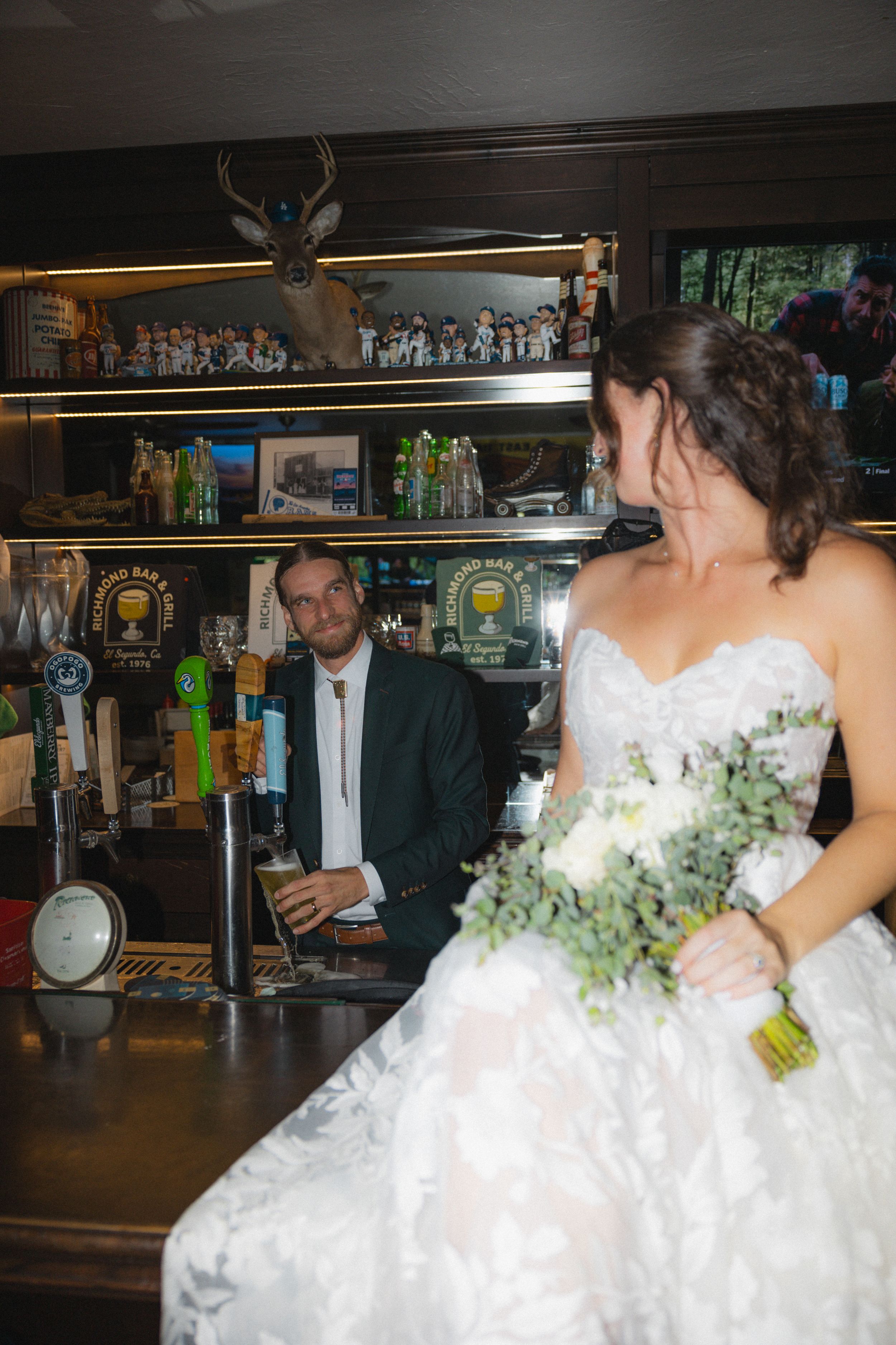 Wedding celebration at a bar with bride in white dress.