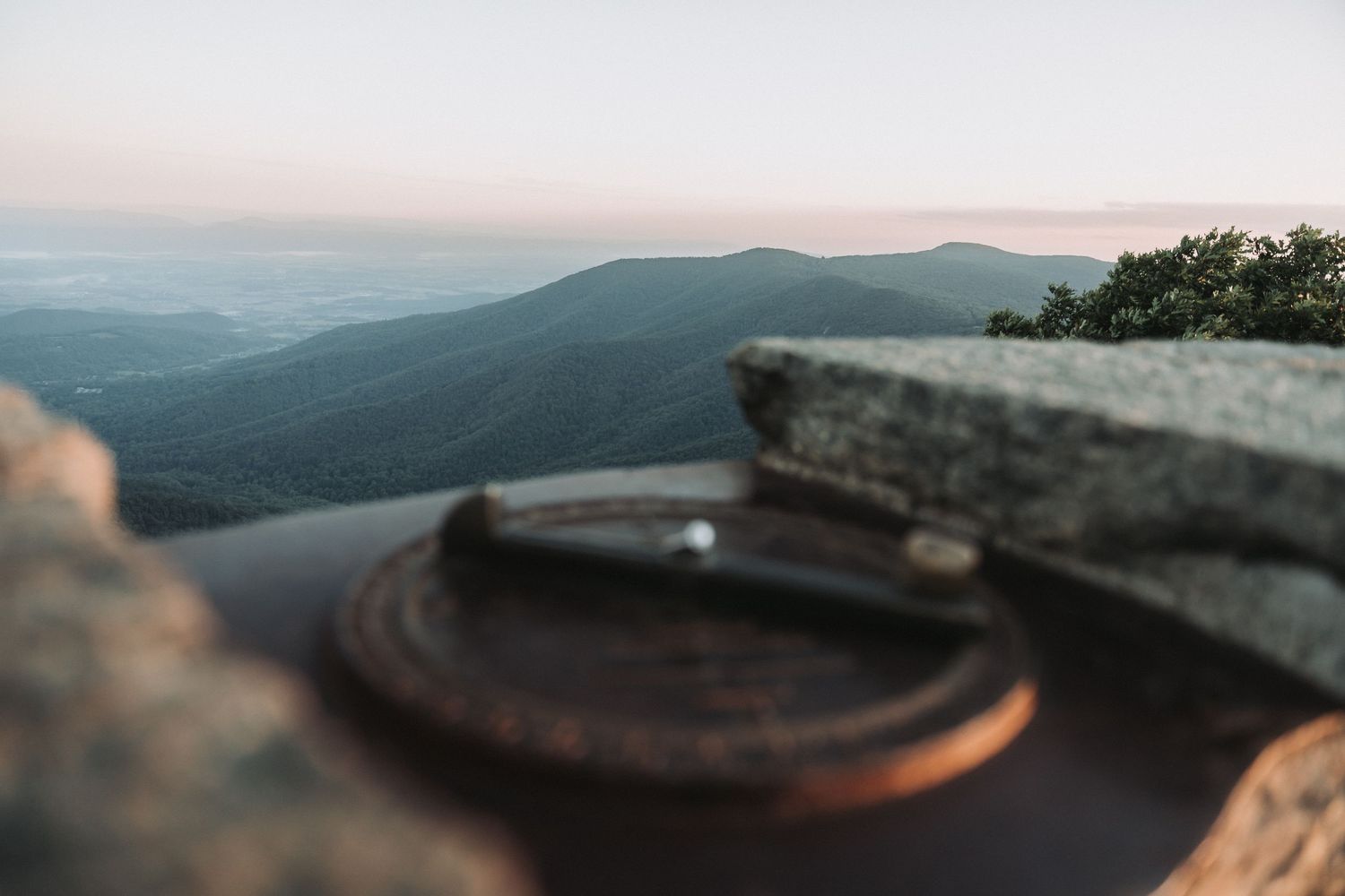 Close-up of turntable record player on mountain overlook during sunset.