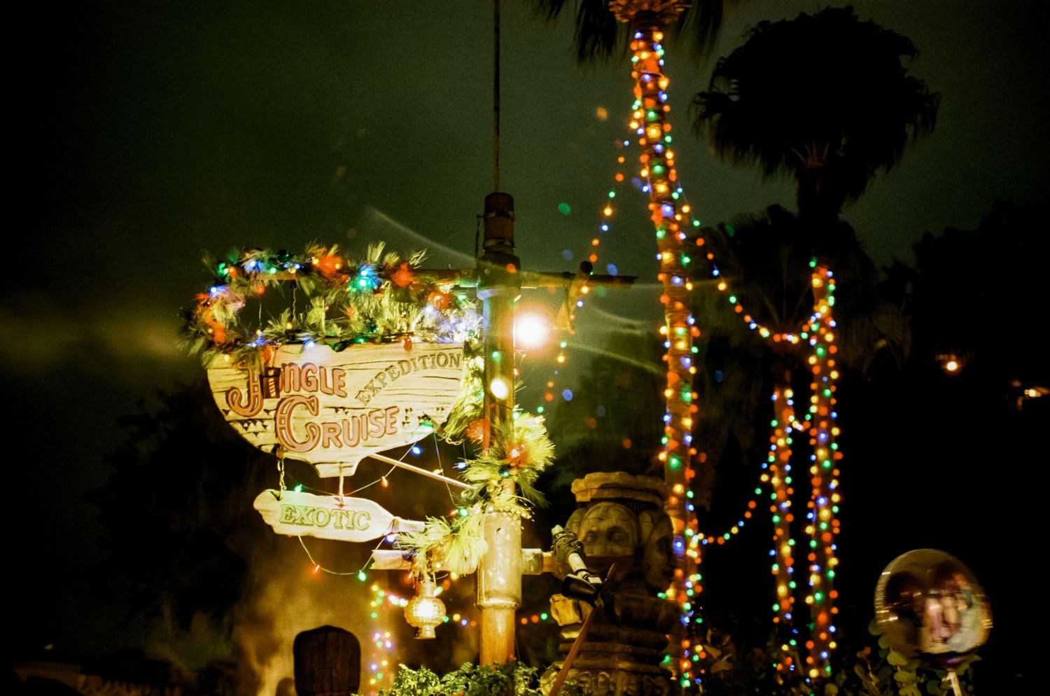 Colorful Christmas lights illuminate a decorative display at Disney World at night.