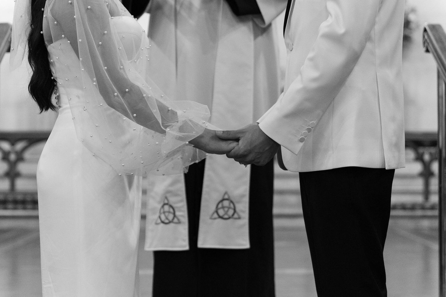 Wedding party members in white attire gathered together outdoors.