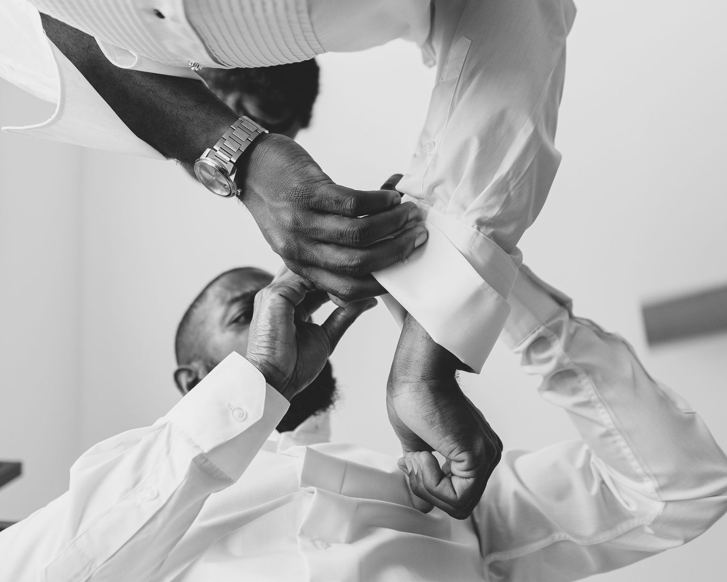 Black and white detail shot of wedding preparation moment.