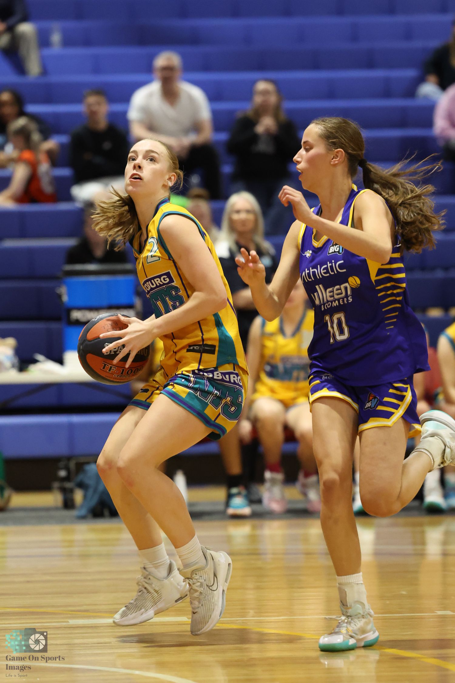 Basketball players from opposing teams compete for possession during fast-paced game action.
