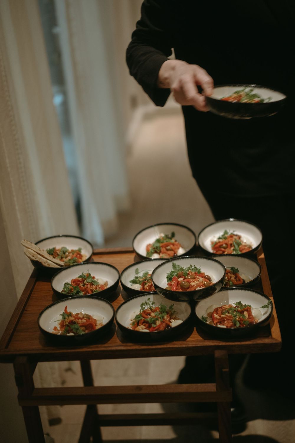 detail of a waitress's hand taking a plate with food from a serving table while being captured by event photographer in Stockholm