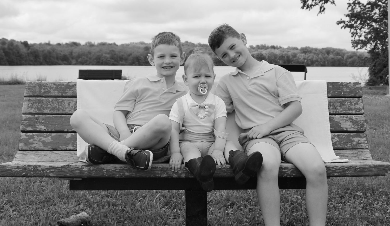 Three siblings sitting together on park bench in black and white photo, Lake Nockamixion, Pennsylvania, brothers