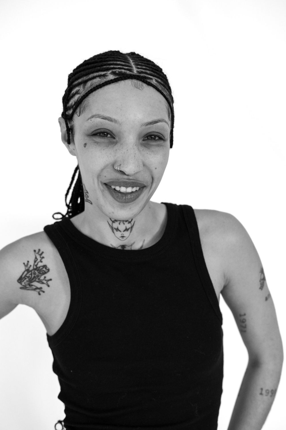 Monochrome studio shot showing energetic pose and confident smile.