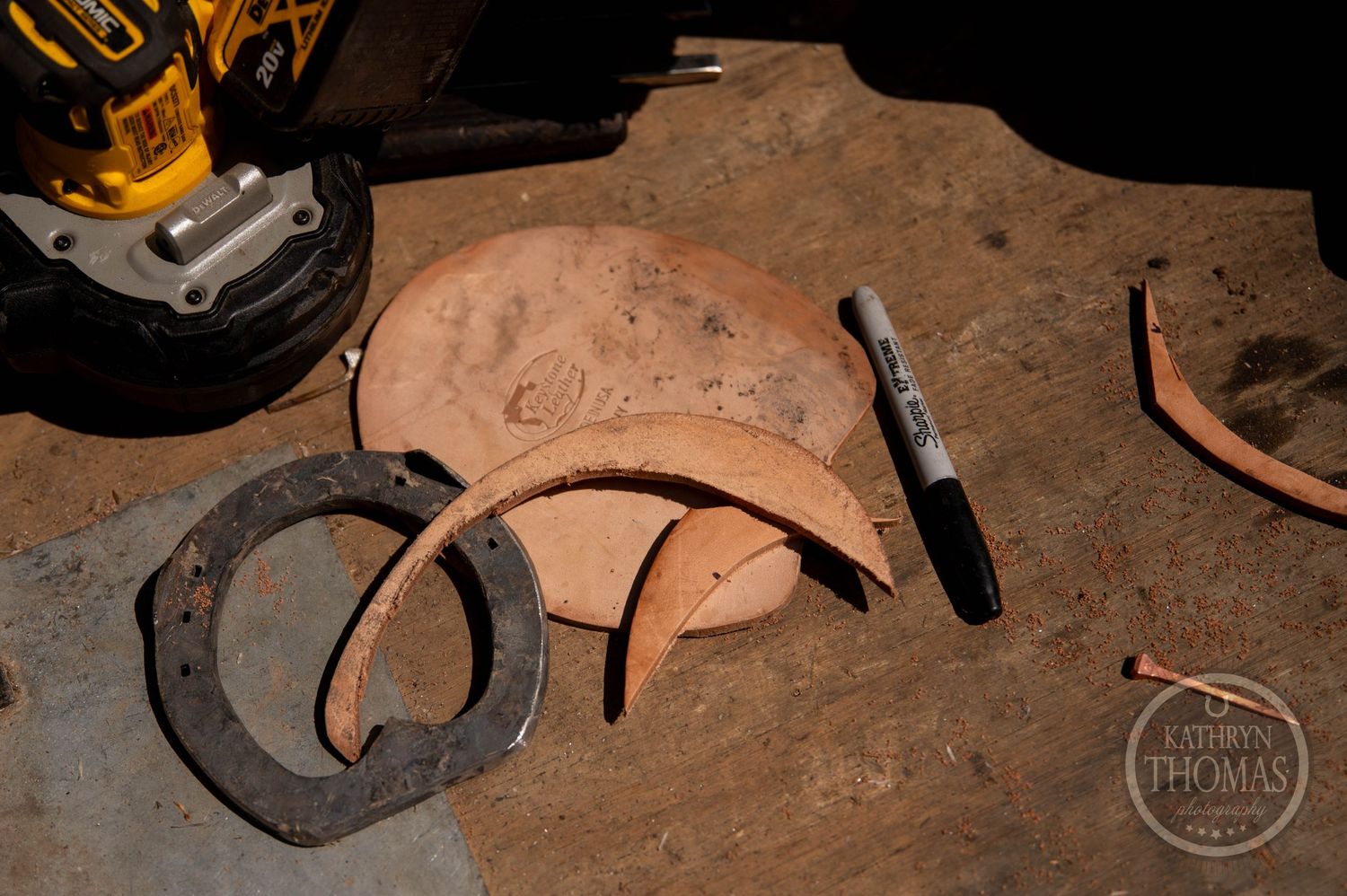 Rustic horseshoes and farrier tools displayed on weathered metal surface.
