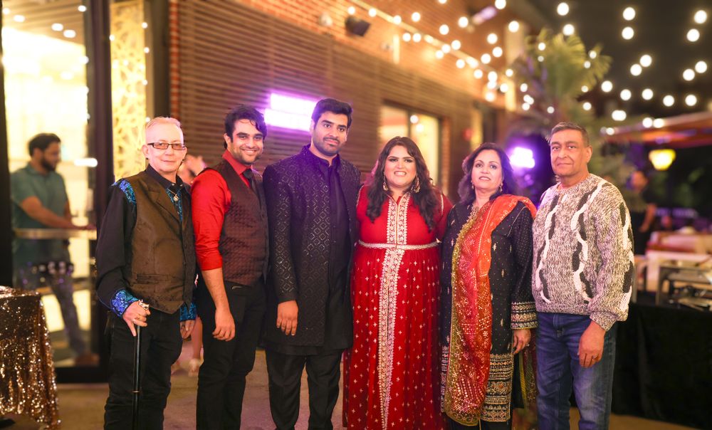 Evening celebration with guests mingling under string lights at an outdoor venue.