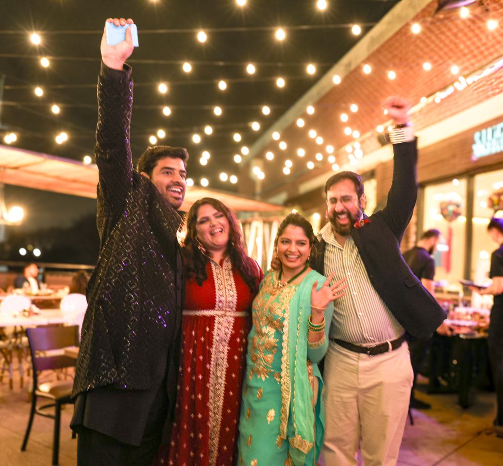 Festive outdoor celebration with guests enjoying themselves under string lights.