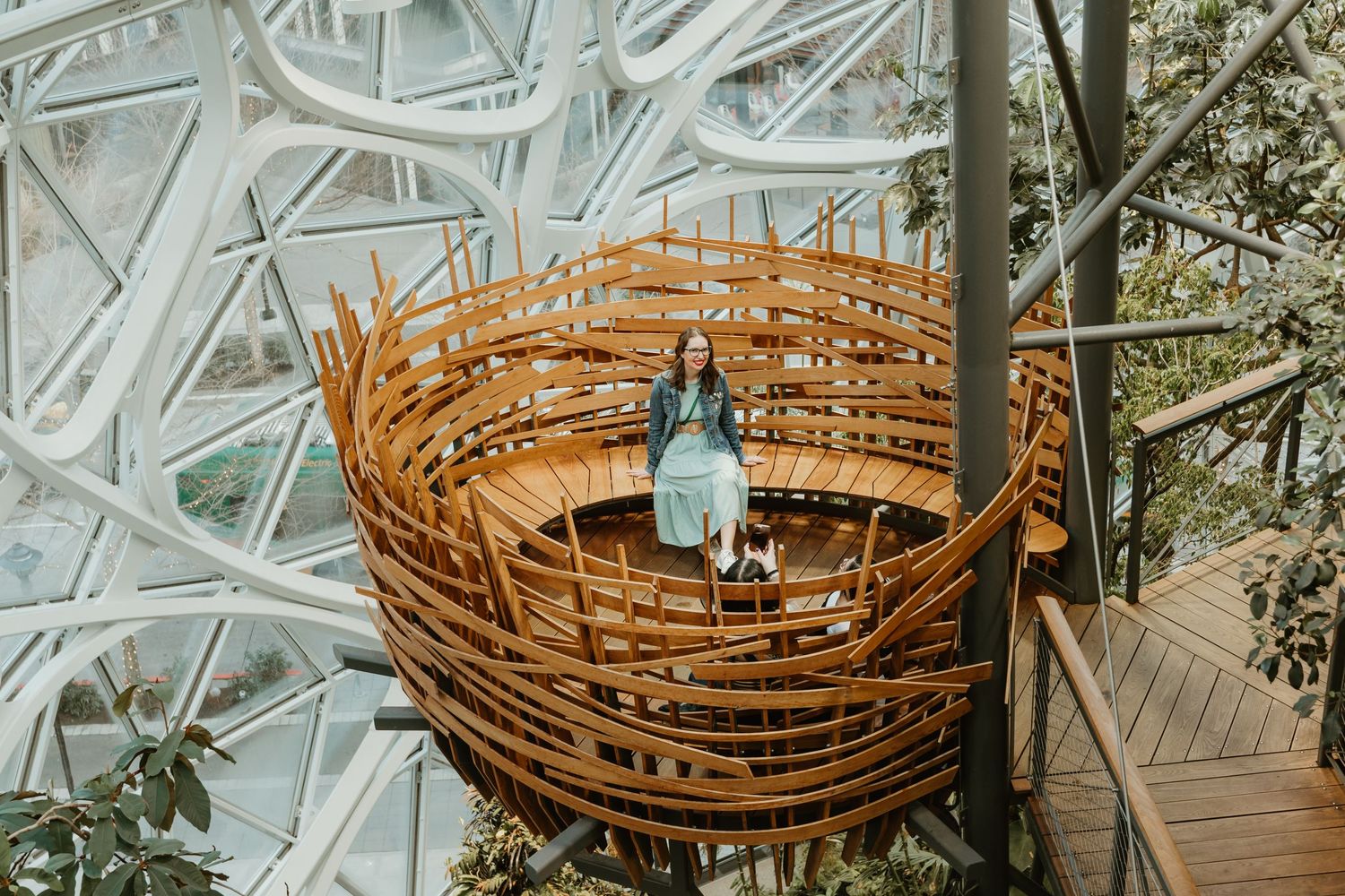 Woven bamboo basket seating area with blue bottle and glass perched inside geometric glass dome structure.