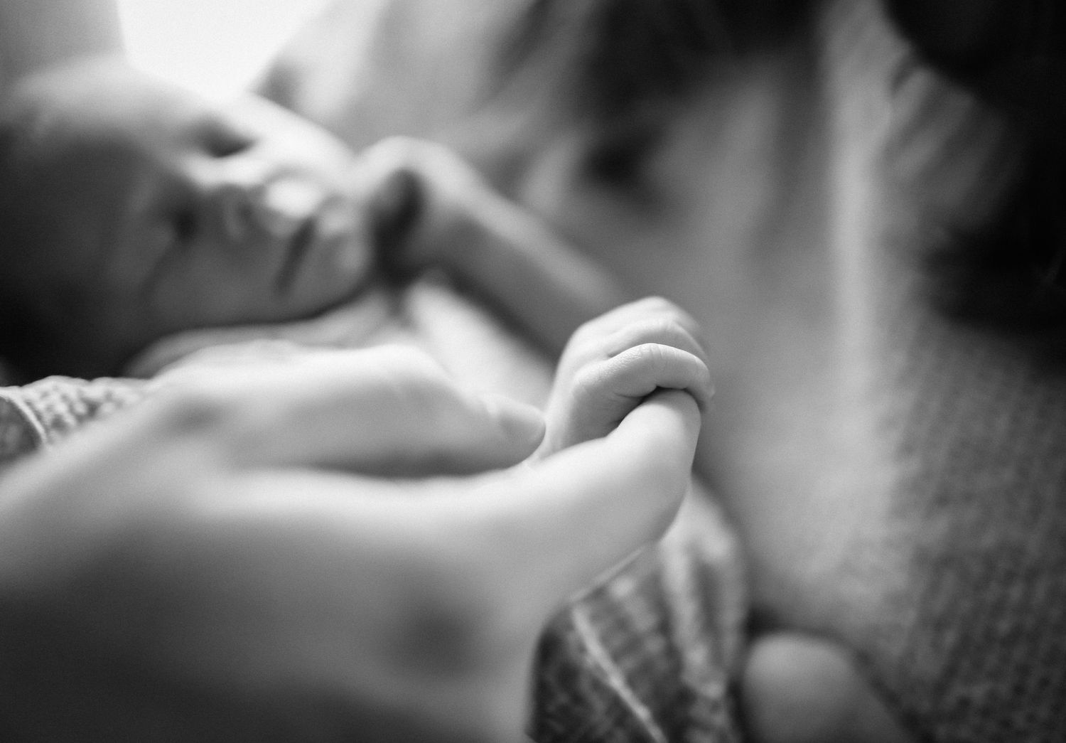 newborn baby girls hand wrapped around daddy's fingers