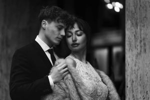 Intimate black and white portrait of a couple embracing in formal evening wear. Next day wedding photography.