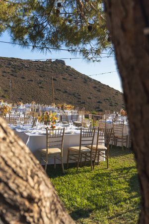 Outdoor wedding reception setup with mountain views and chiavari chairs.