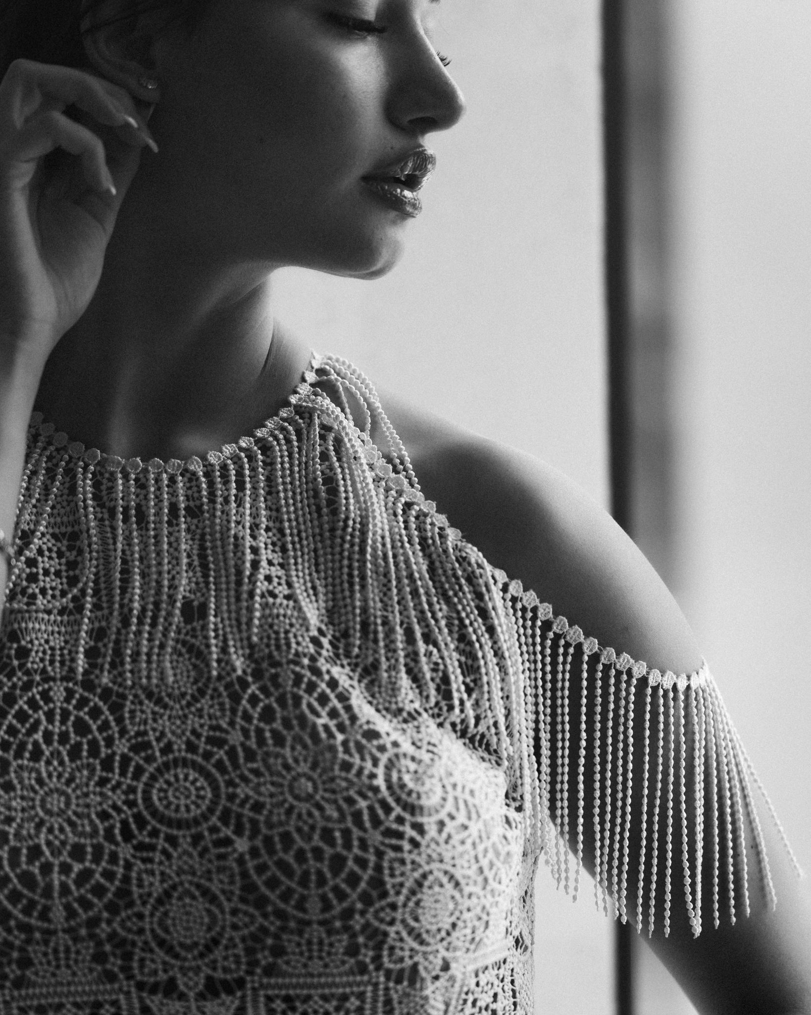 Close-up profile shot showing intricate beaded fringe details on a wedding dress.