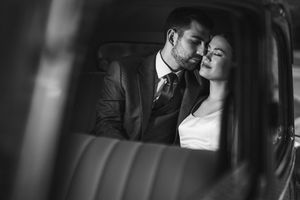 Intimate black and white portrait of a couple sharing a tender moment in a car. Next day wedding photography.